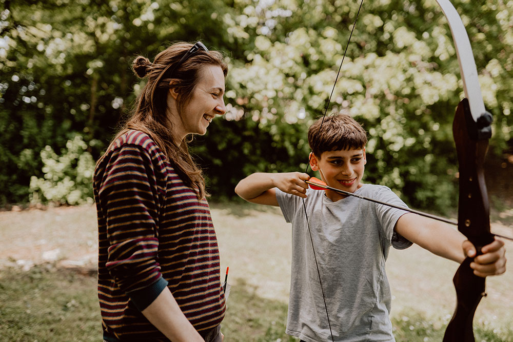 Mutpol Kind schießt mit Pfeil und Bogen