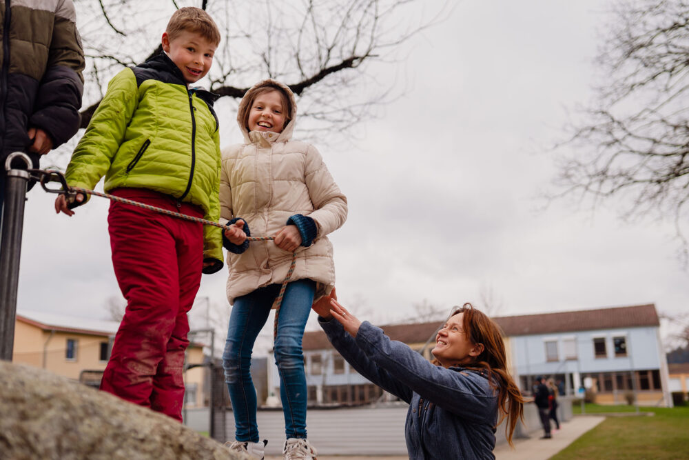 Mutpol Mitarbeiterin hilft lachenden Kindern
