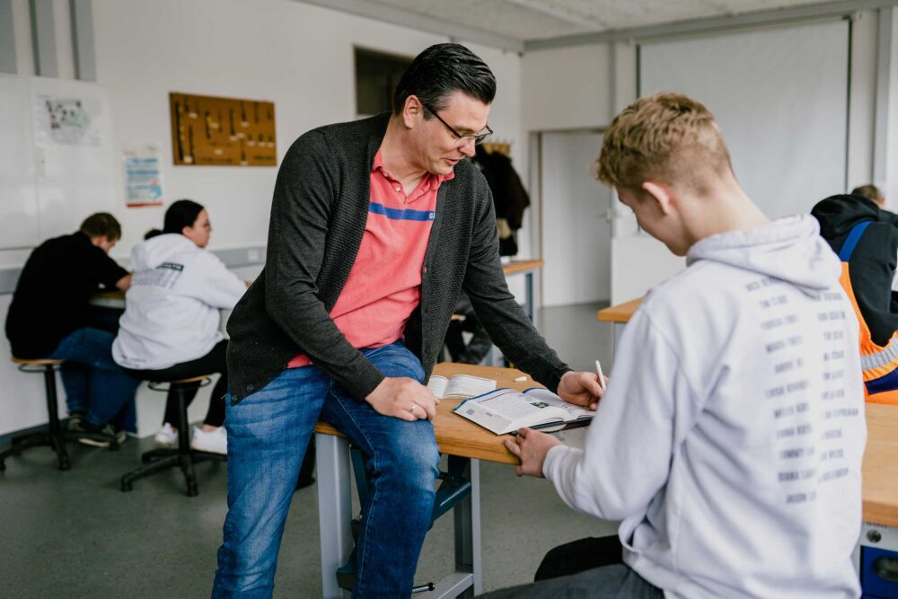 Mutpol Lehrer hilft Schüler im Klassenzimmer