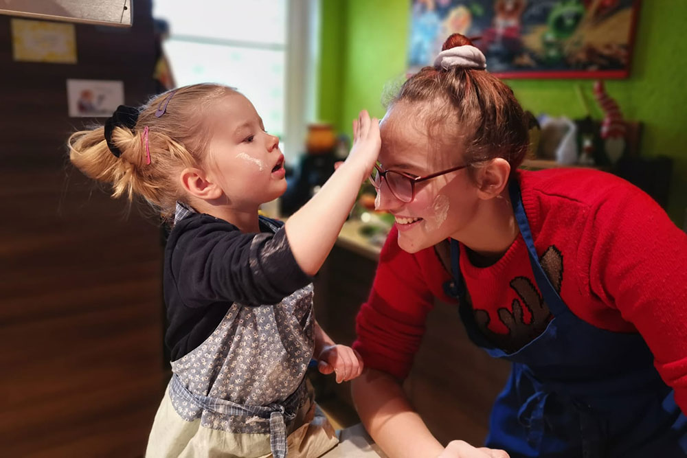 Eine kleine Mädchen und eine erwachsene Frau lachen und spielen gemeinsam